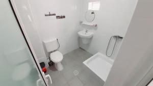 a white bathroom with a toilet and a sink at Vila Tropicana in Eforie Sud +43 photos
