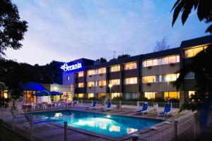 a hotel with a swimming pool in front of a building at Oceania Quimper in Quimper