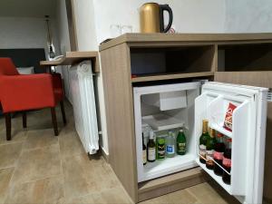an open refrigerator with drinks inside of it at Hotel Fontana in Novi Sad