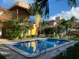 a swimming pool in front of a house at La Dolce Vita Flat & Pousada in Praia do Frances