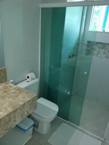 a bathroom with a toilet and a glass shower at Guest House Forno in Búzios