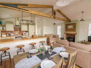 a kitchen and living room with a table and chairs at Hazel Lodge in Llanidloes