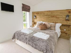 a bedroom with a bed with two towels on it at Hazel Lodge in Llanidloes