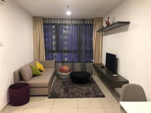 a living room with a couch and a television at Sun-Suite in Shah Alam