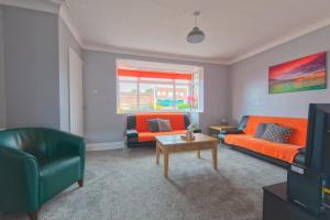 ein Wohnzimmer mit 2 Sofas und einem Tisch in der Unterkunft Bright and Modern Home 4 beds CCTV Parking in Killingbeck