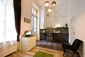 sala de estar con silla y cocina en Balcony Apartment en Budapest