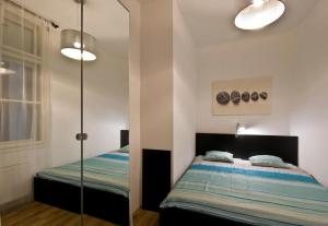 1 dormitorio con 1 cama, 2 luces y espejo en Balcony Apartment en Budapest