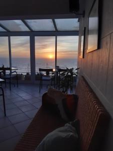 a living room with a couch and a view of the ocean at Albergaria Pedra D'Ouro in São Pedro de Moel