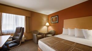 a hotel room with a bed and a desk and chairs at Best Western Paducah Inn in Paducah