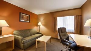 een hotelkamer met een bank en een stoel bij Best Western Paducah Inn in Paducah