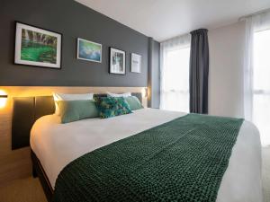 a bedroom with a large bed and a window at Aparthotel & Spa Adagio Vannes in Vannes