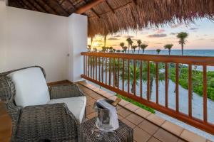 a balcony with a chair and a view of the ocean at Valentin Imperial Riviera Maya All Inclusive - Adults Only in Puerto Morelos