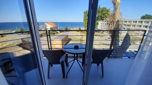 a balcony with a table and chairs and the ocean at Vila Tropicana in Eforie Sud