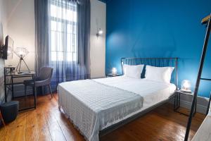 a blue bedroom with a bed and a blue wall at Patio79 Aveiro in Aveiro