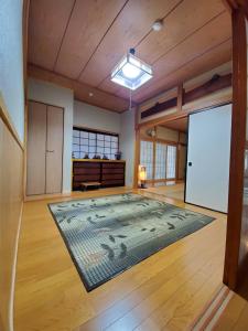 ein großes Wohnzimmer mit einem großen Teppich auf dem Boden in der Unterkunft サムライストリートハウス武家屋敷通り in Daisen