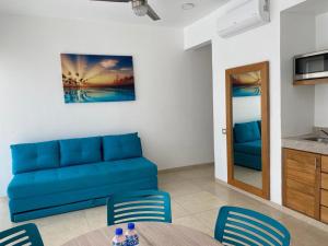a living room with a blue couch and a table at Hotel Huatulco Máxico in Santa Cruz Huatulco