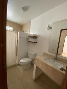 a bathroom with a toilet and a sink and a mirror at Hotel Huatulco Máxico in Santa Cruz Huatulco
