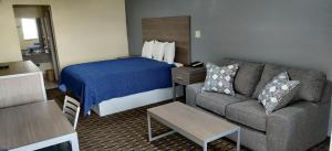 a hotel room with a bed and a couch at Ameristay Inn & Suites in Orange