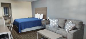 Habitación de hotel con sofá y cama en Economy Inn Motel en Orange