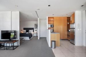 uma sala de estar com uma cozinha e uma sala de estar com uma televisão em Waimahana Apartment 12 em Taupo