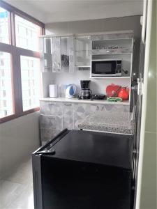 uma pequena cozinha com um frigorífico preto em Royalty Inn em Lima