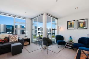 uma sala de estar com um sofá e cadeiras em Waimahana Apartment 12 em Taupo