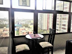 a table and two chairs in a room with windows at Royalty Inn in Lima