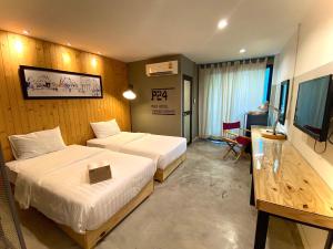 a hotel room with two beds and a television at P24 at Kaset in Bangkok