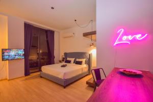 ein Schlafzimmer mit einem Bett und einem Neonschild an der Wand in der Unterkunft Cube 8teens by Nest Home in Johor Bahru