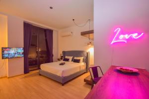 a bedroom with a bed and a neon sign on the wall at Cube 8teens by Nest Home in Johor Bahru