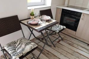 małą kuchnię ze stołem i 2 krzesłami w obiekcie Cozy apartment in the heart of Kecskemet w mieście Kecskemét +10 zdjęć