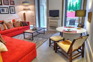 a living room with a red couch and a table at Three Houses & Bedrooms in Porto