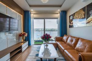 sala de estar con sofá de cuero y mesa en BOM HOMES- THE SAPPHIRE HA LONG RESIDENCE APARTMENt, en Ha Long