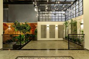 a hallway with plants in a building with lights at Cozrum Homes The Gallery Residence in Ho Chi Minh City
