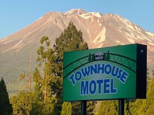 a sign for a mountain motel in front of a mountain at Townhouse Motel in Weed