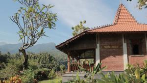 a small brick building with a view of the mountains at Shanti Natural Panorama View Hotel in Singaraja