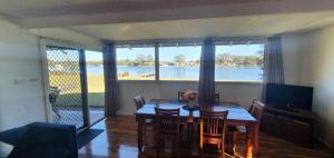 a dining room with a table and a view of the water at Riverfront Cottage in Booderee National Park at Christians Minde in Jervis Bay Village
