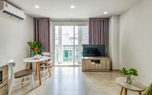 a living room with a television and a table and chairs at Cherry Hotel and Apartment in Ho Chi Minh City