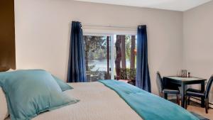 1 dormitorio con cama, mesa y ventana en Willow Suite - Lakeside Retreat, en Victoria