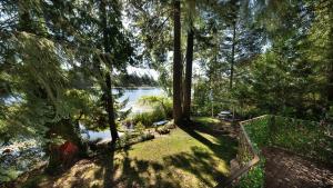 - une vue sur un lac avec des arbres et une clôture dans l'établissement Willow Suite - Lakeside Retreat, à Victoria