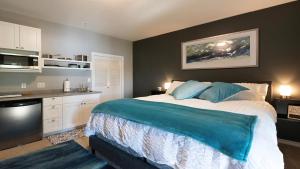 a bedroom with a large bed and a kitchen at Willow Suite - Lakeside Retreat in Victoria