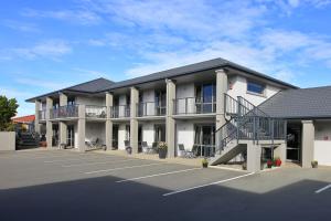 um grande edifício branco com estacionamento em Oamaru Motor Lodge em Oamaru