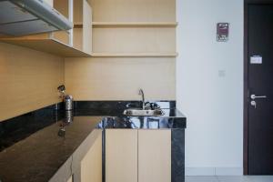 a kitchen with a sink and a counter at Modern and Tranquil 1BR @ Casa De Parco Apartment By Travelio in Tangerang