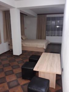 Habitación con 2 camas, mesa y taburete en Къща за гости Динас en Zmeitsa