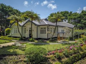 une maison avec un jardin en face dans l'établissement Mirage Kings Cottage, à Nuwara Eliya