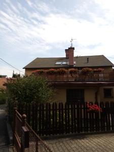 a house with a fence and flowers on the balcony at Apartment Pavel in Velké Poříčí