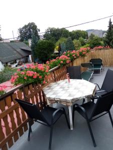 un patio con mesa, sillas y flores en Apartment Pavel, en Velké Poříčí