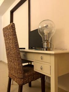 una lampadina seduta su una scrivania con sedia di ALBA AD ORIENTE a Otranto