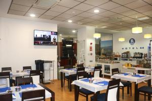 a restaurant with tables and chairs and a kitchen at Hotel 44 in Gijón
