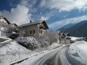 a snow covered street in a village with houses at Ferienhaus Gassner in Navis
